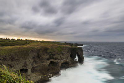 Scenic view of rocks on sea against sky