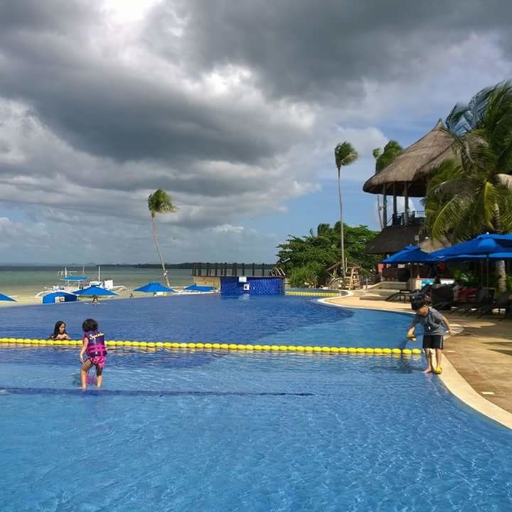 PEOPLE STANDING IN SEA AGAINST SKY