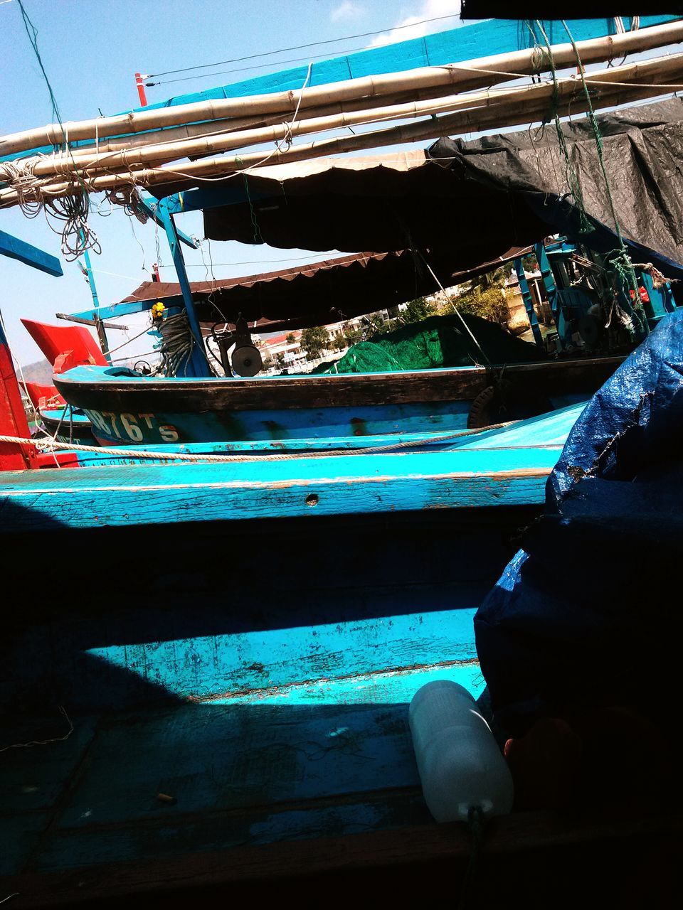 blue, built structure, rope, low angle view, architecture, nautical vessel, metal, abandoned, sky, rusty, outdoors, day, building exterior, transportation, no people, boat, hanging, damaged, metallic, wood - material