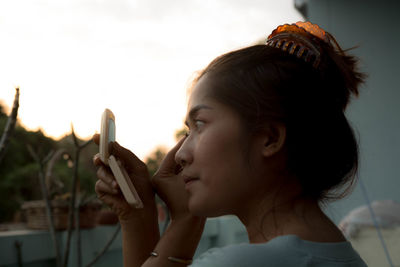 Close-up of young woman holding mirror 