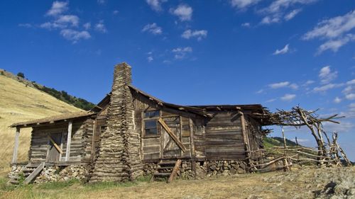 Low angle view of old house on field against sky