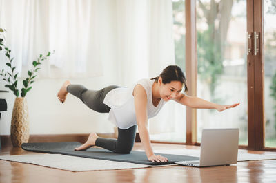 Full length of woman exercising at home