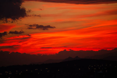 Scenic view of dramatic sky over silhouette landscape