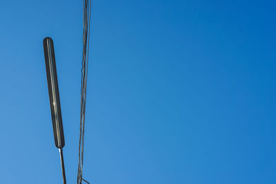 Low angle view of rope against clear blue sky