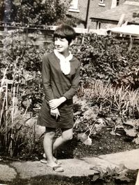 Portrait of young man standing against plants