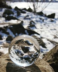 Close-up of crystal ball with reflection in water