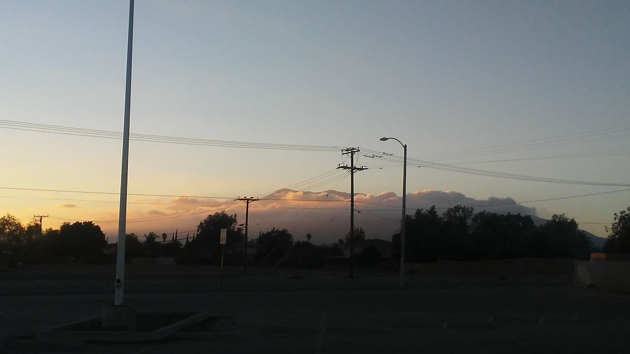 SILHOUETTE ELECTRICITY PYLON AGAINST SKY AT SUNSET