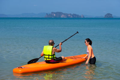 People enjoying in sea against sky