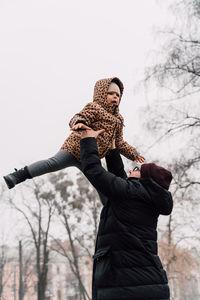 Father playing with child outdoors. happy parenting, family bond.