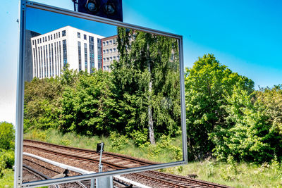 Railroad tracks by trees against clear sky