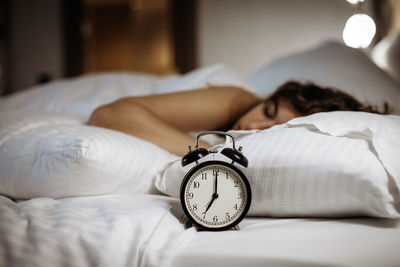 Close-up of clock on bed at home