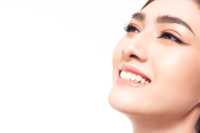 Close-up portrait of a young woman over white background