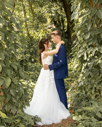 Full length of bride standing against plants