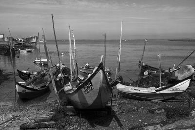 Sailboats moored in sea against sky