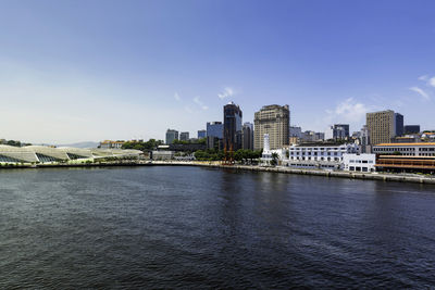 River by buildings in city against sky