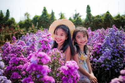 Portrait of smiling girl against purple flowering plants