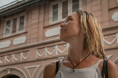 Low angle view of woman standing against building