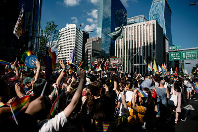 People on street against buildings in city