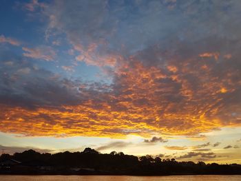 Scenic view of dramatic sky over silhouette landscape