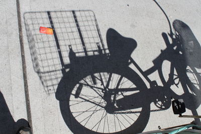 Low section of man with bicycle on shadow