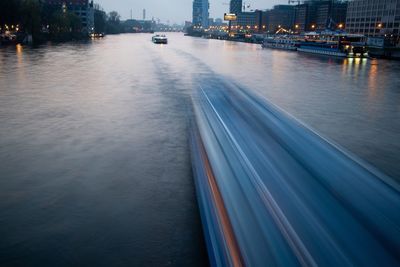 Blurred motion of illuminated city by river