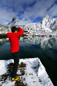 Rear view of person standing on snowcapped mountain