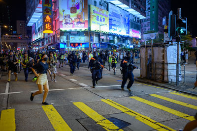 People walking on city street at night