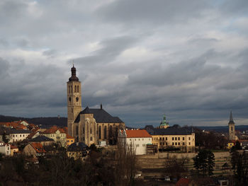 Buildings in city against cloudy sky