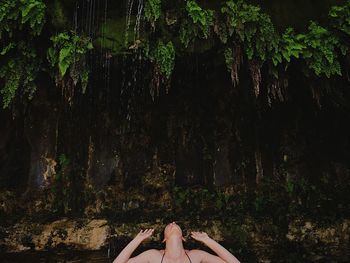 Low section of woman standing on tree trunk