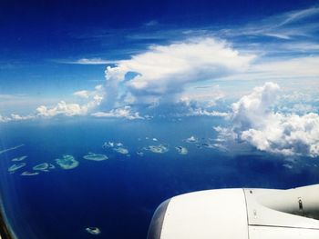 Aerial view of cropped airplane flying over landscape