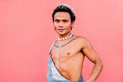 Portrait of young man against pink background