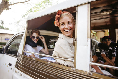 Happy woman enjoying vacation while sitting in van with son