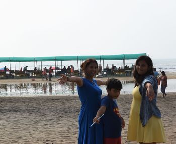 People on beach against clear sky