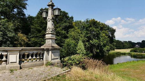 Built structure in park by lake against sky
