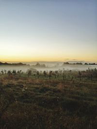 View of countryside landscape against clear sky during foggy weather