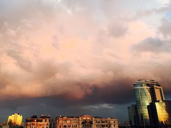 Low angle view of city against sky during sunset