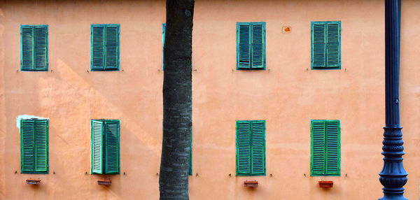 Full frame shot of residential building and its green windows