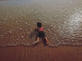 Rear view of boy on beach