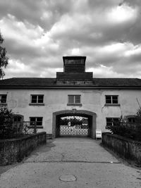 Footpath leading towards old building against sky