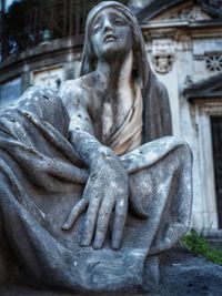 Low angle view of buddha statue in cemetery