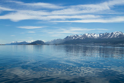 Scenic view of sea and snowcapped mountains against sky