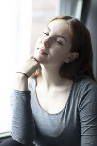 Portrait of beautiful young woman with eyes closed