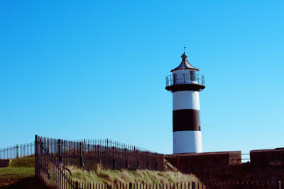 Low angle view of lighthouse against clear blue sky