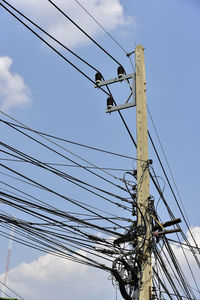 Low angle view of electricity pylon against sky