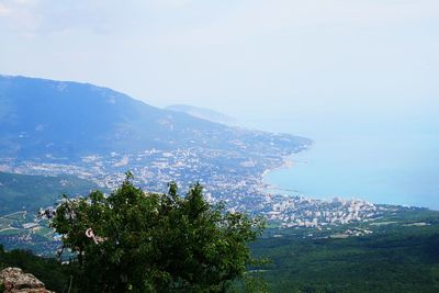 Scenic view of townscape by sea against sky