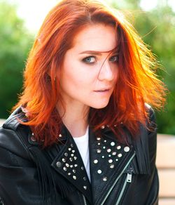 Portrait of young redhead woman standing outdoors