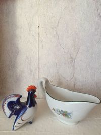 Close-up of bowl on table against wall at home