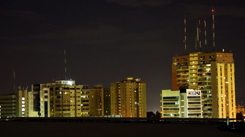 Illuminated cityscape against sky at night