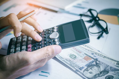 Midsection of man using smart phone on table