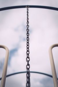 Low angle view of metallic chain hanging on outdoor play equipment at playground